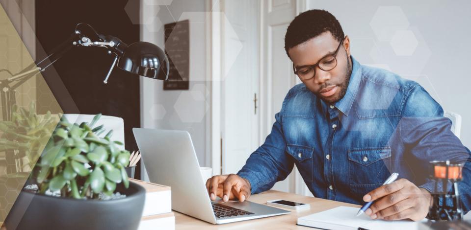 Remote worker using laptop computer and mobile phone to work from home.