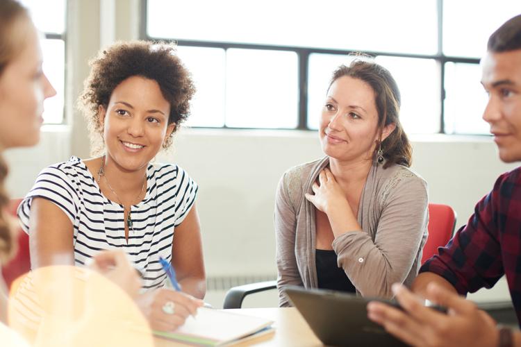 Diverse students gathering around a table to learn English