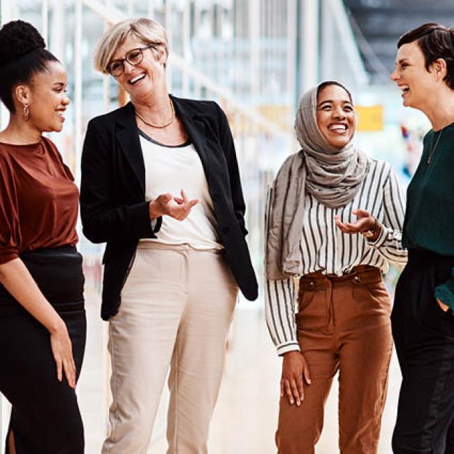 Group of female coworkers smiling and laughing outside office building