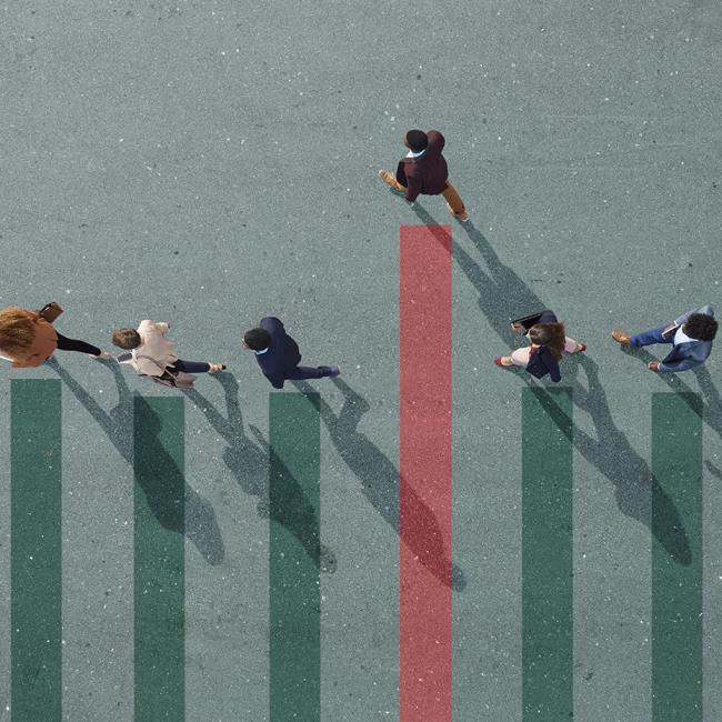 Overhead view of 6 employees walking on a green floor. 5 of the employees are in a line. 1 employee has stepped out of line and surpassed the others.