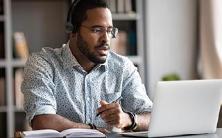 Male professional participating in workplace learning via laptop